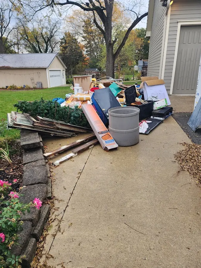Dumpster being loaded with debris for Estate Cleanout Dumpster Rental in Maquoketa